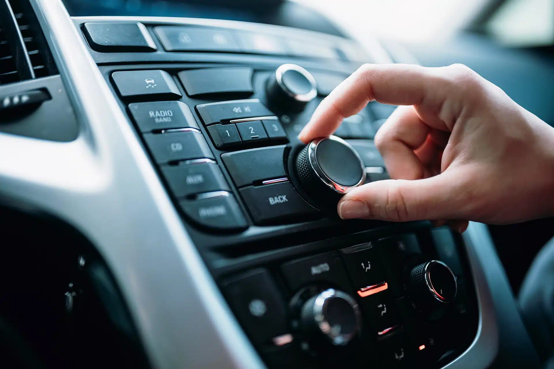 hand turning dial on car radio