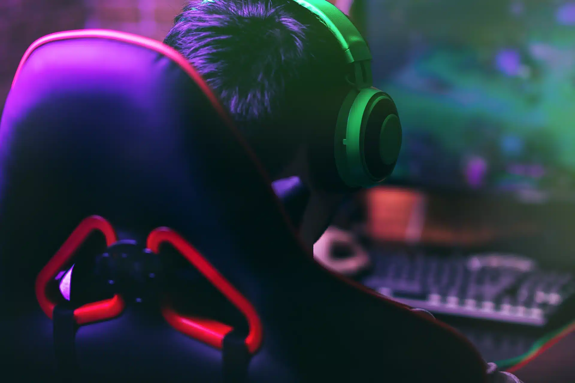 back of gaming chair and gamer's head wearing headphones