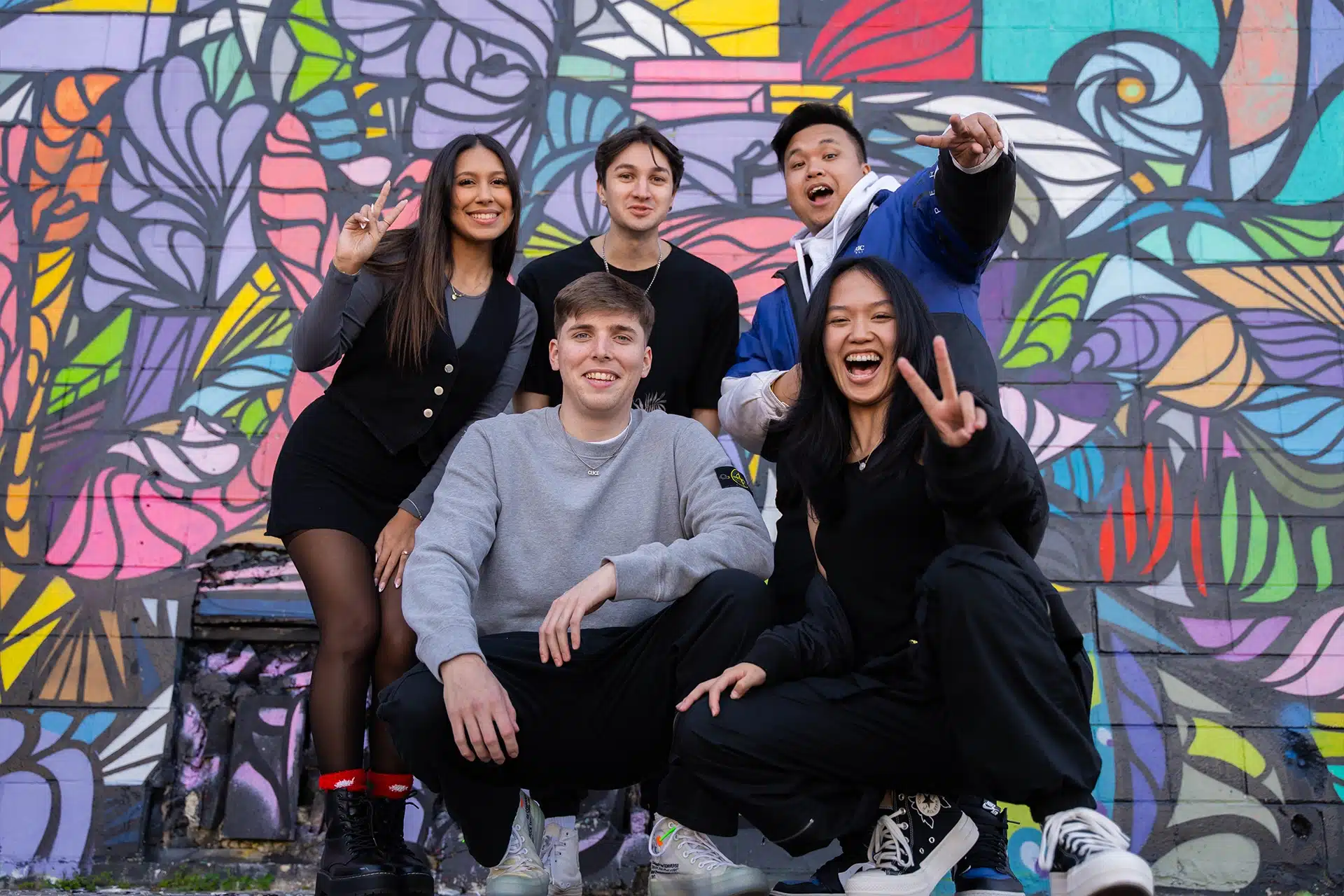 Outlaws entertainment group of gen z influencers posing in front of wall mural
