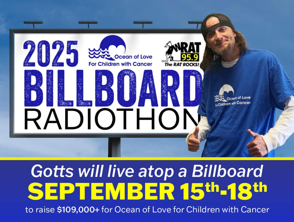 Gotts standing in front of Event billboard
